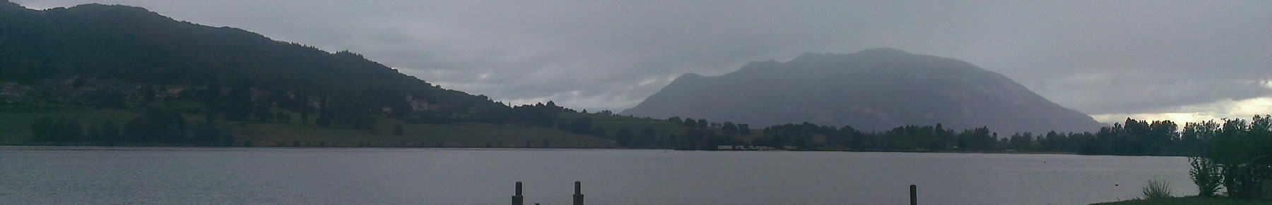 Banner showing hills behind lake on a cloudy day