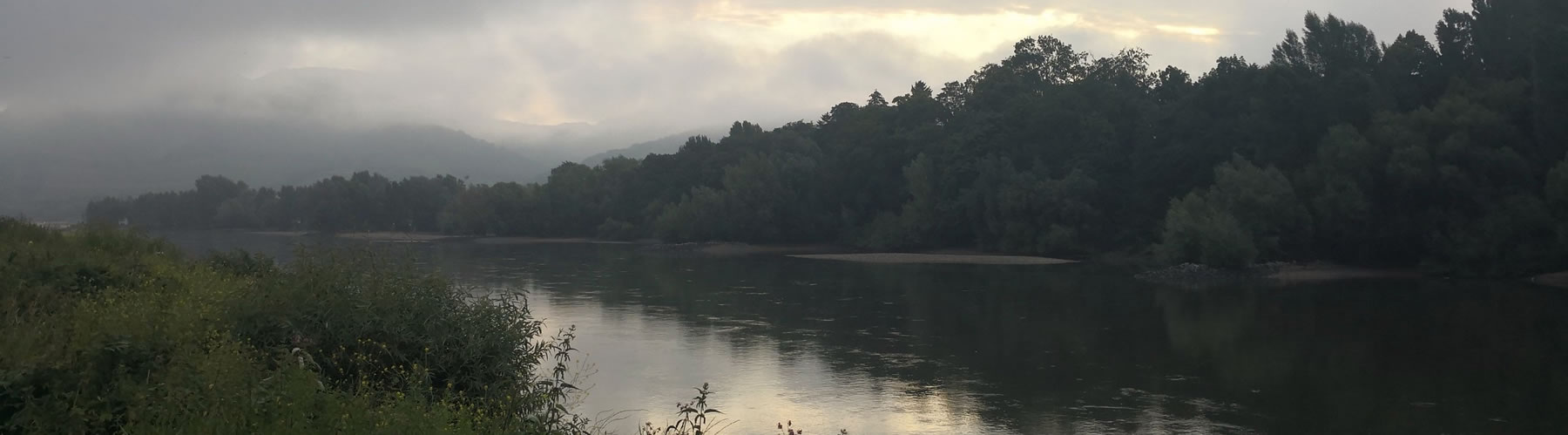 Banner showing river with hills shrouded in low cloud